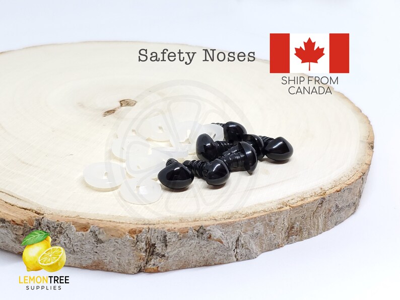 Puede incluir: Primer plano de narices de seguridad negras y arandelas blancas, dispuestas sobre una rodaja de madera. El texto "Safety Noses" es visible. Tambi&eacute;n est&aacute; la bandera canadiense.
