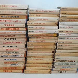 Könnte beinhalten: Eine Sammlung von Vintage-Observer-Büchern mit Titeln wie "Wild Flowers", "Insects" und "Automobiles". Die Bücher haben cremefarbene Einbände mit Titeln in Rot und Schwarz. Die Buchrücken sind gestapelt.