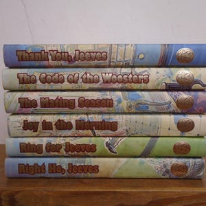 May include: A stack of six hardback books with illustrated spines featuring the titles Thank You, Jeeves; The Code of the Woosters; The Mating Season; Joy in the Morning; Ring for Jeeves; and Right Ho, Jeeves, each with a gold circular emblem.