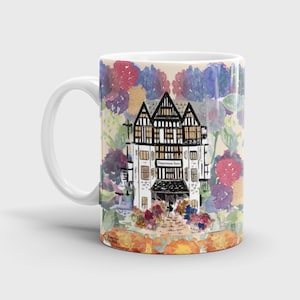 May include: White ceramic mug with a colorful floral design featuring a watercolor illustration of a building with the text "Department Store" above the entrance. The mug has a black handle.
