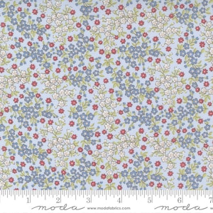 May include: A blue fabric with a white and red floral pattern. The fabric is covered in small flowers and has a subtle green leaf pattern. The fabric is marked with a ruler and the text "moda" appears twice.