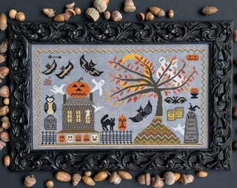 May include: A black framed cross-stitch embroidery depicting a spooky Halloween scene with a haunted house, a tree with a crescent moon, bats, ghosts, and a graveyard. The embroidery is on a gray background with a zig-zag pattern at the bottom.