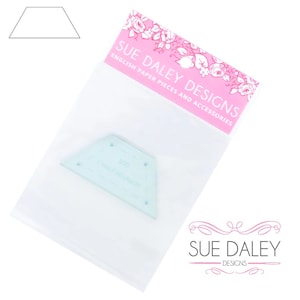 May include: A clear plastic template for crafting, shaped like a half hexagon. The template is packaged in a clear plastic bag with a pink label that reads "Sue Daley Designs English Paper Pieces and Accessories".