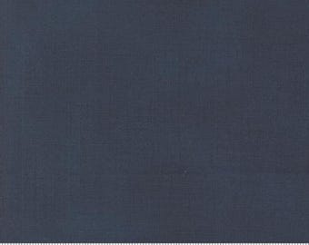 May include: A plain navy blue fabric with a fine woven texture. A ruler along the bottom edge shows measurements in inches. The fabric is suitable for various sewing projects, including quilting, clothing, and home furnishings.