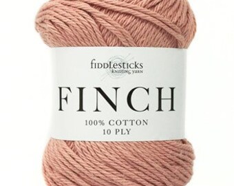 May include: A ball of Finch 100% cotton knitting yarn in a dusty rose color. The label reads "Fiddlesticks Knitting Yarn" and "100% Cotton 10 Ply". The yarn is tightly wound and ready for knitting or crocheting projects.