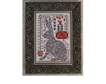 May include: A framed cross-stitch embroidery featuring a grey rabbit with a white and red floral design. The embroidery includes the year "1828" and the alphabet.