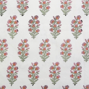 May include: White fabric with a repeating floral pattern. The design features clusters of pink and orange flowers with green leaves and stems. The flowers are arranged in a symmetrical layout across the fabric.