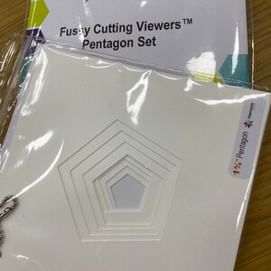 Könnte beinhalten: Eine weiße Plastikverpackung mit einem Satz von fünf weißen, fünfeckigen Fussy-Cutting-Schablonen aus Kunststoff. Die Verpackung ist mit "1 3/4" Pentagon Imprezio" beschriftet.
