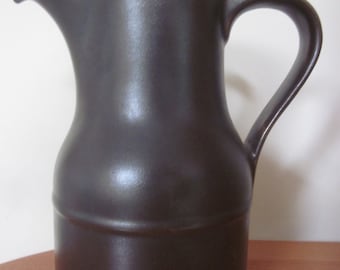 May include: A brown ceramic coffee pot with a lid and a handle. The pot has a rounded body and a slightly flared spout.