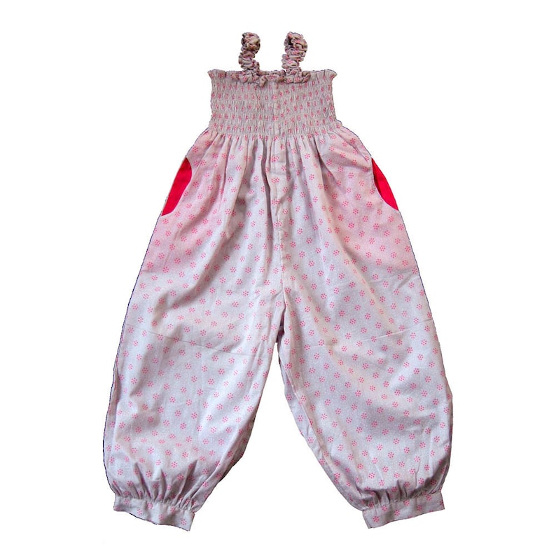 May include: A white and pink floral print jumpsuit with pink ruched straps and red heart-shaped pockets.