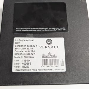 Puede incluir: Una caja negra con una etiqueta blanca con el logotipo de Versace y detalles del producto, incluyendo "Le R&egrave;gne Animal" y "Bowl 12 cm sq. flat". La caja tambi&eacute;n tiene una tarjeta de autenticidad negra.