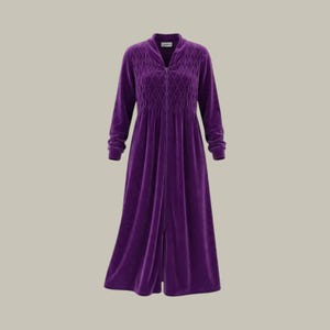 May include: A long-sleeved, floor-length purple robe made of a soft velvet-like fabric. The garment features a full-length front zipper, a V-neckline, and a quilted diamond-patterned texture across the chest and shoulder area.