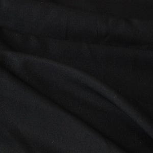 Könnte beinhalten: Nahaufnahme von schwarzem Stoff mit sichtbaren Falten und Textur. Das dunkle Material drapiert sich und erzeugt Schatten und Lichtreflexe, die die Weichheit und den Fluss des Stoffes betonen. Das Gesamtbild ist glatt und elegant.