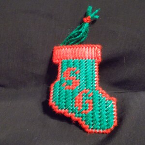 May include: A green and red stocking ornament with the letter "S" embroidered on it.