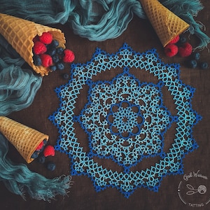 May include: A blue and white tatted doily with a scalloped edge. The doily is on a brown surface with two waffle cones filled with blueberries and raspberries. The text "Doily #6 PDF Tatting Pattern" is at the top of the image.
