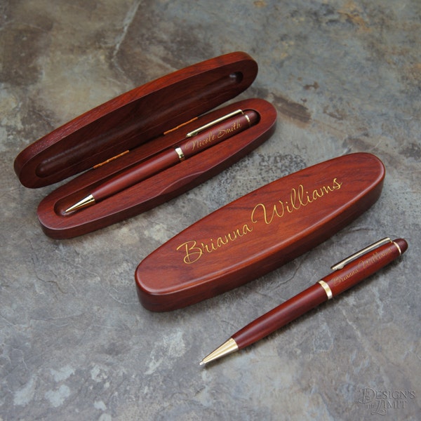 May include: Two wooden pen boxes with engraved names, "Nicole Smith" and "Brianna Williams". Each box contains a brown pen with a gold trim.