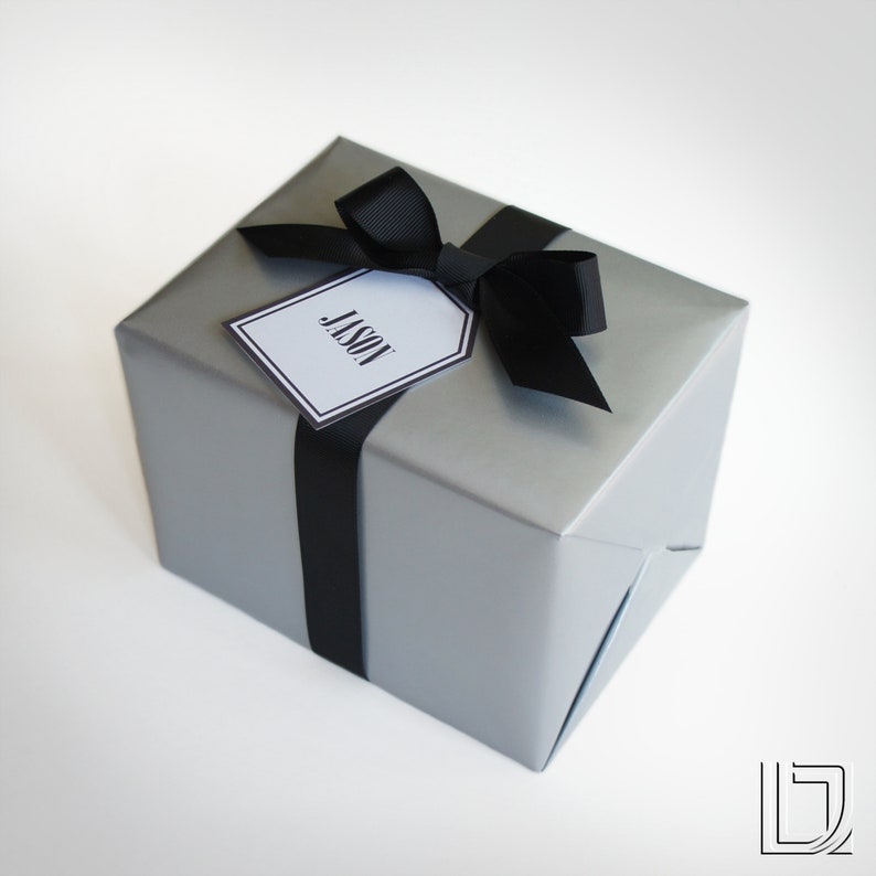 May include: A silver gift box with a black ribbon and bow. A white gift tag with black lettering reads "Jason".