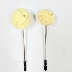 May include: Two yellow fire poi with black handles and silver metal cables. The poi are made of braided cotton and are tied in a knot.