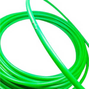 Könnte beinhalten: Eine aufgerollte, hellgrüne Springseil vor weißem Hintergrund. Das Seil hat eine leuchtende, einfarbige Farbe und scheint aus einem flexiblen Material zu bestehen. Das Bild hebt die glatte Textur des Seils und seine geschwungene Form hervor.