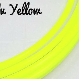 Könnte beinhalten: Helles, gelbes, gebogenes Rohr vor weißem Hintergrund. Der Text "Uv Yellow" ist in schwarzer Schreibschrift oben links geschrieben. Das Rohr scheint aus flexiblem Material zu bestehen.