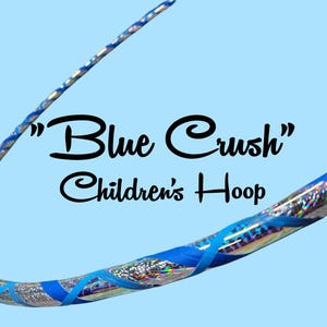 Könnte beinhalten: Ein blauer und silberner Kinder-Hula-Hoop mit dem Text "Blue Crush Children's Hoop". Der Reifen hat blaues Klebeband und silberne holografische Akzente auf hellblauem Hintergrund. Ein lustiges Spielzeug.