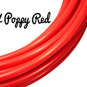 Puede incluir: Tubos rojos brillantes, curvados y en capas, sobre un fondo blanco. El texto "UK Poppy Red" está escrito en cursiva. Los tubos parecen lisos y flexibles. El color es rojo amapola.