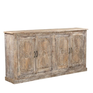 May include: A light-colored wooden cabinet with four doors. Each door features a sunburst design carved into the wood. The cabinet has a rectangular shape and is suitable for storage.