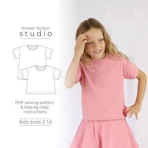 Può includere: Una ragazza indossa una maglietta e una gonna rosa. Accanto a lei c'è un disegno a tratto di un modello di maglietta. Il testo sull'immagine recita "thread faction studio", "PDF sewing pattern & step-by-step instructions" e "Kids sizes 2-14".