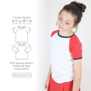 May include: A white t-shirt with red and navy blue raglan sleeves. The t-shirt has a navy blue trim around the neckline. The t-shirt is shown on a young person. The text "thread faction studio" and "PDF sewing pattern & step-by-step instructions Kids sizes 2-14" is shown on the left side of the image.
