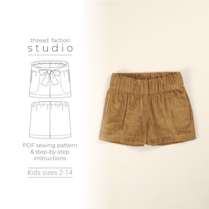 May include: A sewing pattern for kids shorts in sizes 2-14. The pattern includes instructions for making the shorts with a bow detail. The image shows a pair of brown corduroy shorts.