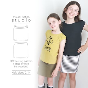 May include: A sewing pattern for a skirt with a bee graphic on the front. The pattern is available in sizes 2-14. The pattern is for a skirt with a waistband and a straight hem. The pattern is for a skirt that can be made in a variety of fabrics.