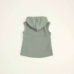 May include: A sleeveless hooded shirt in a light green color. The shirt is made of a soft, ribbed fabric.