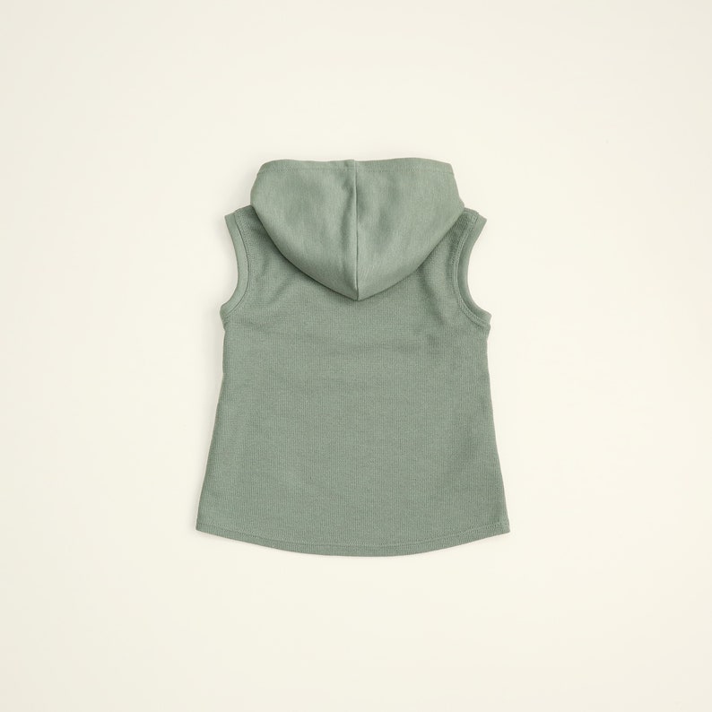 May include: A sleeveless hooded shirt in a light green color. The shirt is made of a soft, ribbed fabric.
