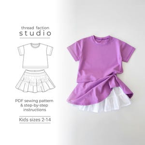 Può includere: Un completo per bambini lilla, composto da una maglietta a maniche corte e una gonna con orlo bianco a balze. L'immagine presenta anche un disegno a tratto del completo e il testo "thread faction studio", "PDF sewing pattern & step-by-step instructions" e "Kids sizes 2-14".