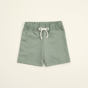 May include: Sage green drawstring shorts with a white drawstring.