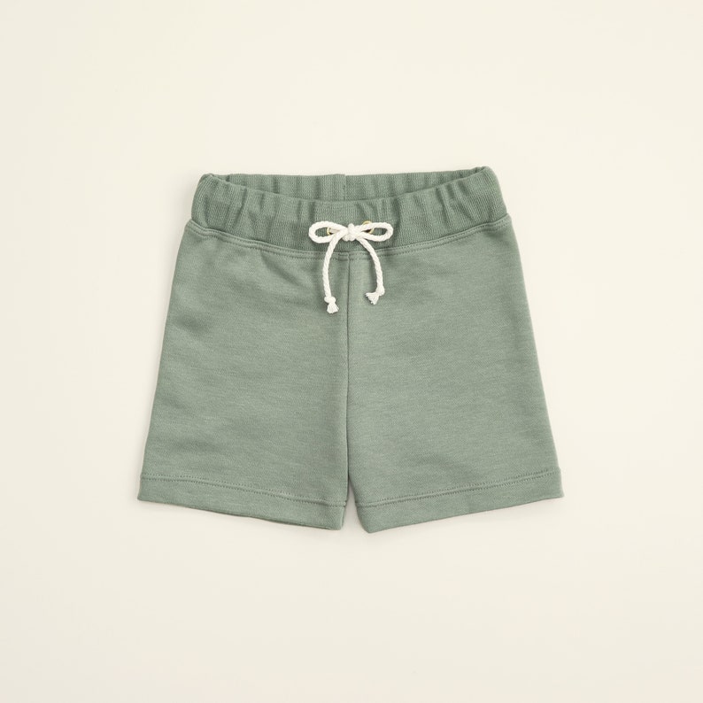 May include: Sage green drawstring shorts with a white drawstring.