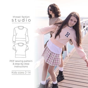 May include: A PDF sewing pattern for a kids' sweatshirt with long sleeves and a crew neck. The pattern includes step-by-step instructions and is available in sizes 2-14. The image shows two girls wearing the sweatshirt in different colors.