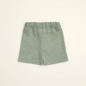 May include: A pair of light green shorts with an elastic waistband.