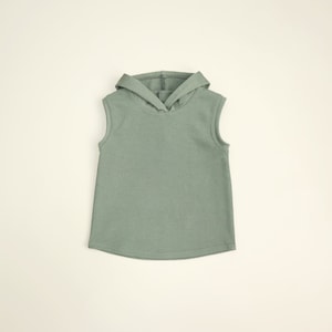 May include: A sleeveless hooded shirt in a light green color. The shirt has a relaxed fit and a simple design.