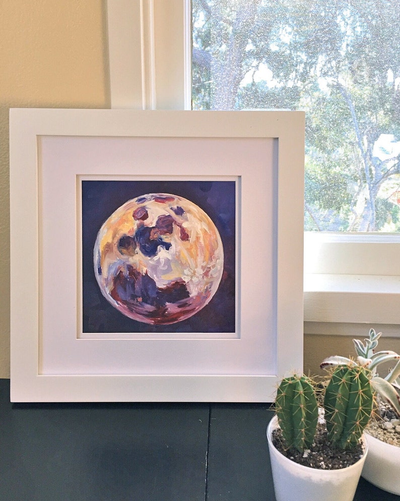 May include: A framed painting of a purple, yellow, and white moon on a dark blue background.