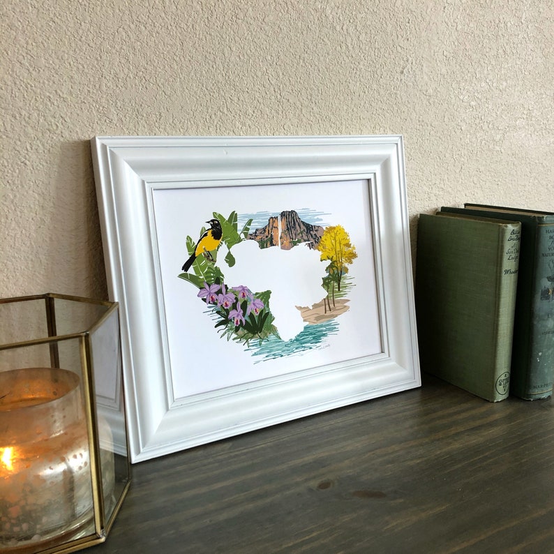 May include: A white framed print of a colorful illustration of a bird, flowers, and a mountain range. The illustration is in the shape of a heart.