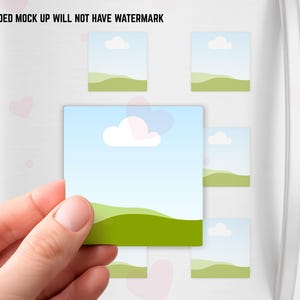 May include: A hand holding a square magnet with a landscape design of a blue sky, white cloud, and green hills. Several similar magnets are attached to a white surface. The text "DOWNLOADED MOCK UP WILL NOT HAVE WATERMARK" is at the top.