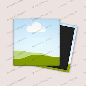 May include: Square magnet with a landscape design featuring a blue sky, white cloud, and green hills. The magnet is partially open, revealing a black magnetic backing. The text "Moments To Magnets" is repeated around the edges.