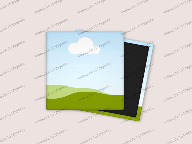 May include: Square magnet with a landscape design featuring a blue sky, white cloud, and green hills. The magnet is partially open, revealing a black magnetic backing. The text "Moments To Magnets" is repeated around the edges.