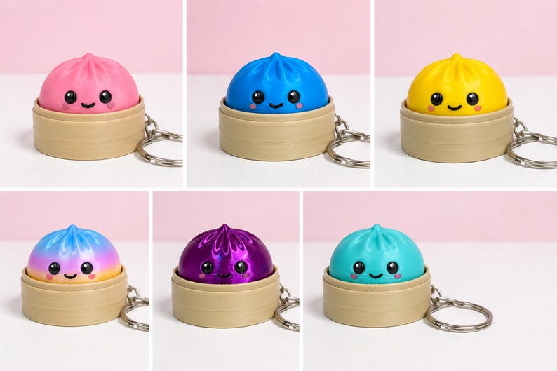 Puede incluir: Una colecci&oacute;n de seis llaveros de dumpling, cada uno con un personaje colorido y sonriente dentro de una base de vaporera circular de color tostado. Los dumplings vienen en rosa, azul, amarillo, turquesa, un acabado met&aacute;lico morado y degradado.