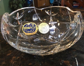 May include: A clear glass bowl with a cut crystal design. The bowl has a sticker on the side that reads "BOHEMIA Crystal Made in Czech Republic Hand Cut 24% PbO Czech Republic".