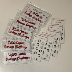 May include: A collection of clear plastic pouches and white cards with red text that reads "Casino Savings Challenge." The pouches contain cards labeled for savings amounts from $100 to $500. The cards feature casino chip designs.