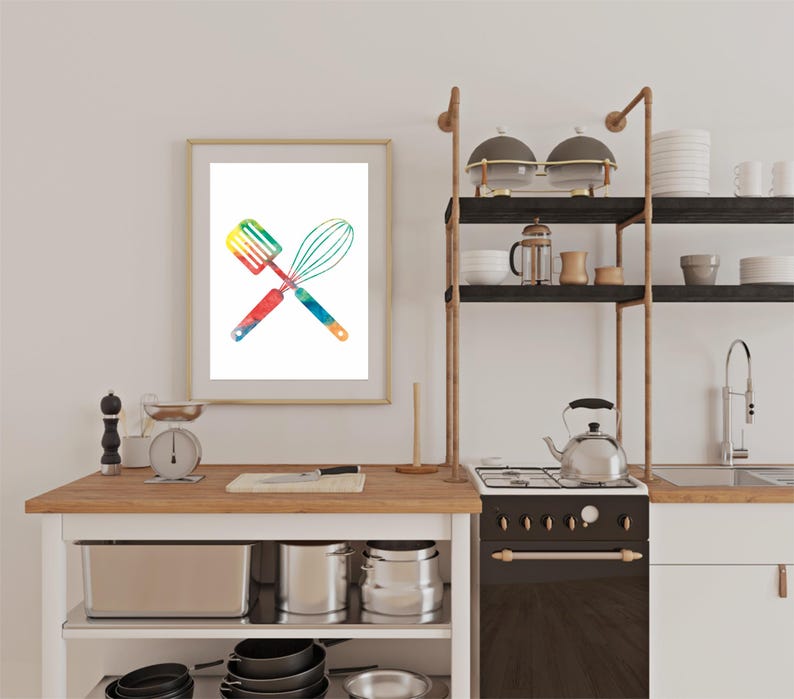 May include: A framed watercolor print of a spatula and whisk crossed over each other. The utensils are painted in a rainbow of colors.