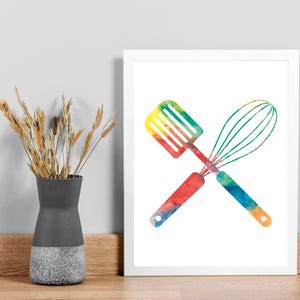 May include: A watercolor illustration of a spatula and whisk crossed over each other. The utensils are painted in a rainbow of colors.