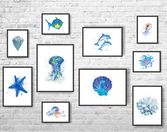 Puede incluir: Un conjunto de 10 pinturas de acuarela enmarcadas que representan varias criaturas marinas y conchas. Las pinturas están en una gama de colores blanco y azul y se exhiben en una pared de ladrillo blanco.